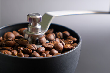 roasted coffee beans ground in a manual coffee grinder
