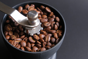 roasted coffee beans ground in a manual coffee grinder
