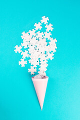 Cone with white puzzle pieces, blue background, spreading the jigsaw parts, searching for ideas and...