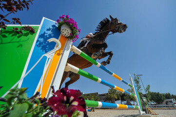 Bottom view on the rider on horse jumping over a hurdle during the equestrian event	