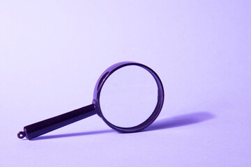 Magnifying glass on a violet background. Search concept. Search for employees, ideas, resources, money