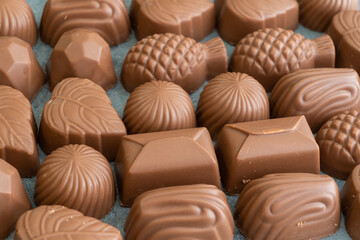 A box of chocolates of various shapes and flavors. The concept of a first date and confectionery sweets. Chocolates in box top view.