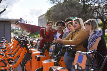 Group of latin LGBTQ university friends taking a selfie together in the park before of a bike...