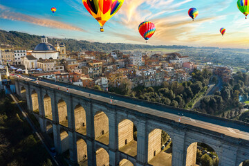 aerial view at sunset of the Ariccia bridge with hot air balloons
