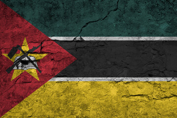 Patriotic cracked wall background in colors of national flag. Mozambique
