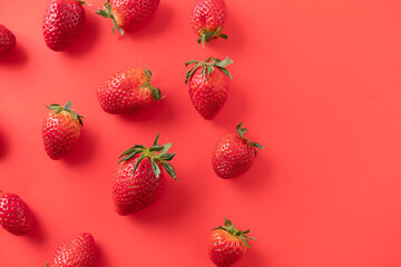 Organic strawberries on red background with copy space. Top view. Vegan and vegetarian concept. Berries