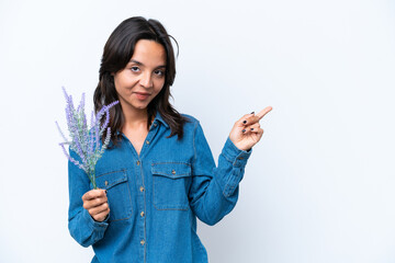 Young hispanic woman holding lavender isolated on white background pointing finger to the side
