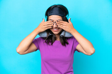 Young caucasian woman with Inflatable Travel Pillow isolated on blue background covering eyes by hands