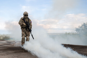 Military soldier standing with a rifle in a burning building