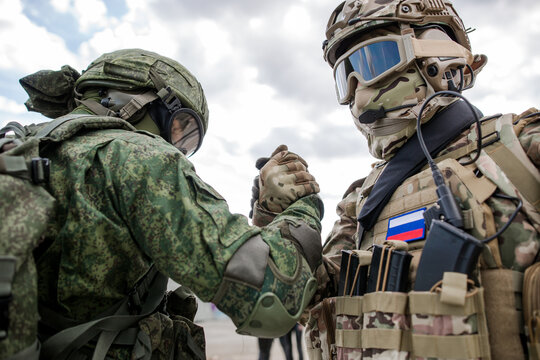 Handshake of two Russian military soldiers against the sky