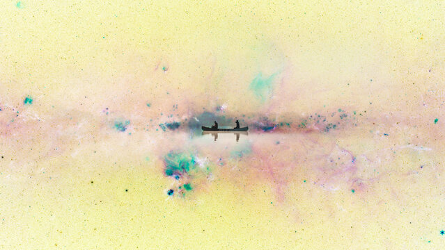 Digital collage of a canoe boat floating in inverted space on 'Peony Nebula'. Abstract dreamy concept, digital art of boating and travel to stars.