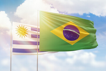 Sunny blue sky and flags of brazil and uruguay