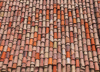 Texture of old weathered red and orange roof tiles.