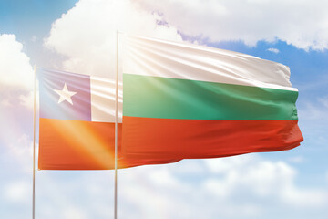 Sunny blue sky and flags of bulgaria and chile