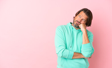 Senior dutch man isolated on pink background with tired and bored expression