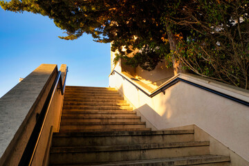 Stairway to heaven in the rays of the rising sun. Concrete staircase with railings