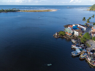 Beautiful village on the edge of the river flowing into the sea on the horizon seen from a drone in...
