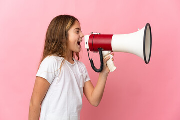 Child over isolated pink background shouting through a megaphone to announce something in lateral...