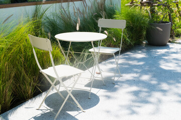 Empty white table and chair in garden.