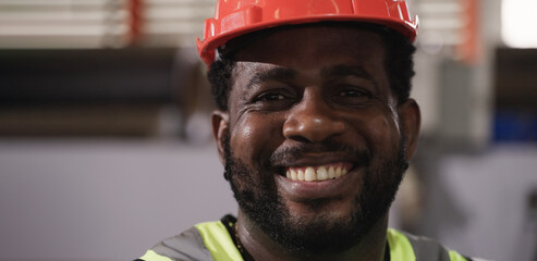 Portrait of happy professional African American man worker wears safety helmet standing smile and...