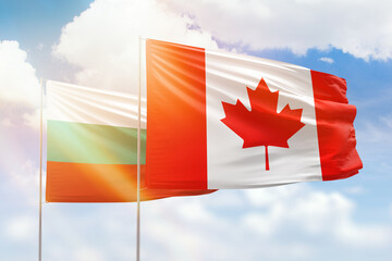 Sunny blue sky and flags of canada and bulgaria