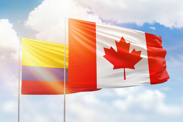 Sunny blue sky and flags of canada and colombia