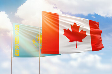 Sunny blue sky and flags of canada and kazakhstan