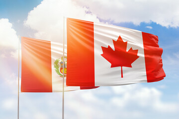 Sunny blue sky and flags of canada and peru
