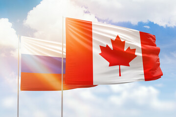 Sunny blue sky and flags of canada and russia
