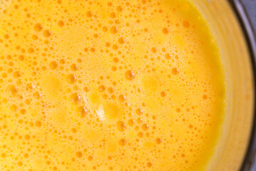 fresh orange juice closeup, top view, foam and bubbles