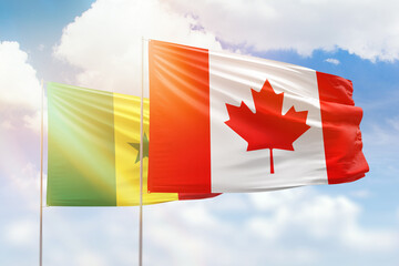 Sunny blue sky and flags of canada and senegal