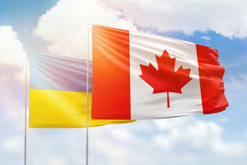 Sunny blue sky and flags of canada and ukraine