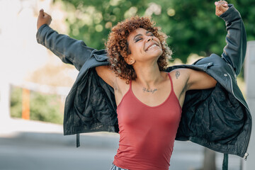 young urban girl smiling and dancing happily in the street