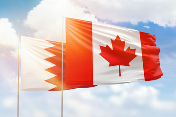 Sunny blue sky and flags of canada and bahrain