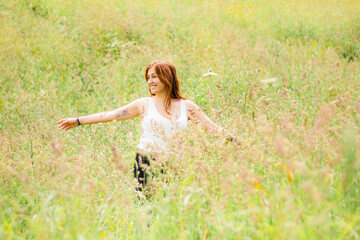 Naklejka na ściany i meble Girl on flower field, young woman, beautiful outdoors portrait.