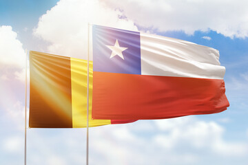 Sunny blue sky and flags of chile and belgium
