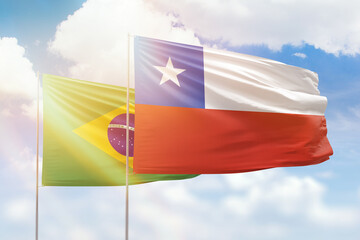 Sunny blue sky and flags of chile and brazil