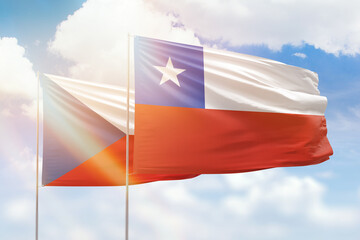 Sunny blue sky and flags of chile and czechia