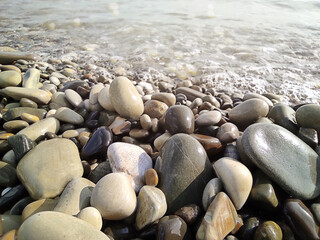 Pebble stones on sea shore natural background. Soft partial focus