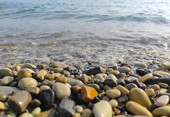 Pebble stones on sea shore natural background. Soft partial focus