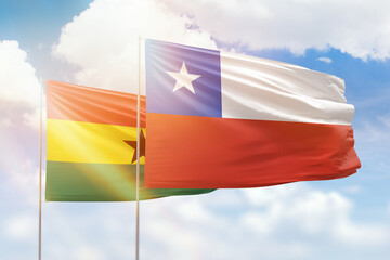 Sunny blue sky and flags of chile and ghana