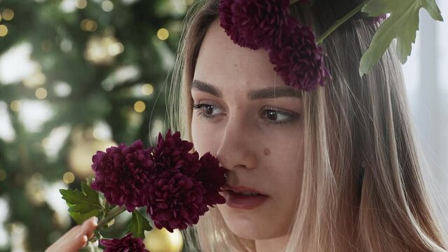 Close-up of a girl's face with clean smooth skin, with beautiful dahlias next to her face. Model