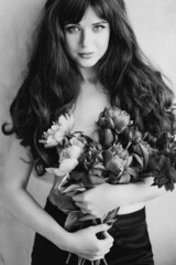 a beautiful woman topless with long hair and a bouquet of peonies. beauty.