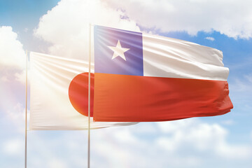 Sunny blue sky and flags of chile and japan