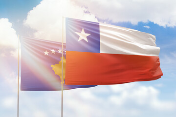 Sunny blue sky and flags of chile and kosovo