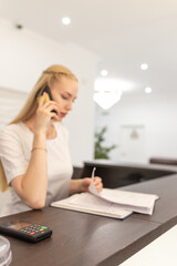 Beautiful female receptionist or secretary at reception in medical clinic or hospital. Soft focus