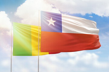 Sunny blue sky and flags of chile and mali