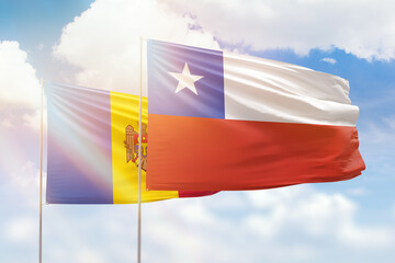 Sunny blue sky and flags of chile and moldova