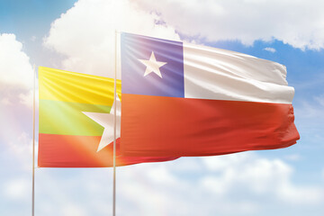 Sunny blue sky and flags of chile and myanmar