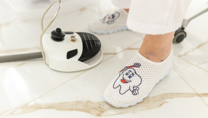 Feet of the dentist in shoes with pictures, the subject of dentistry. Professional shoes